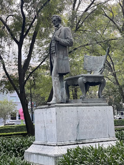 Monumento a Abraham Lincoln en el centro del parque, con bandera estadounidense en la base.